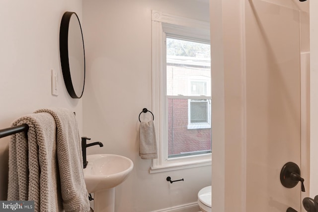 full bath featuring baseboards, a sink, and toilet