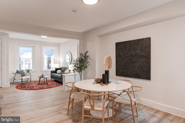 dining area with light wood-style floors and baseboards