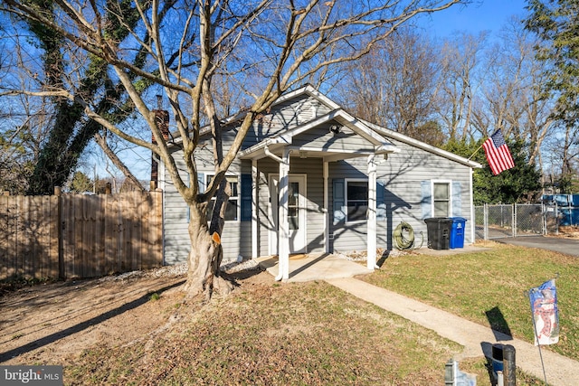 bungalow-style home with a gate, a front yard, and fence