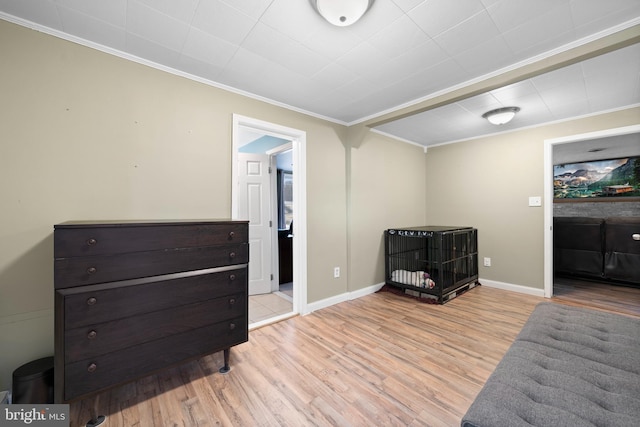 living area with crown molding, baseboards, and wood finished floors