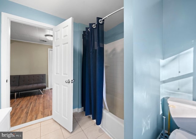 full bath featuring tile patterned floors, baseboards, and shower / bath combo with shower curtain