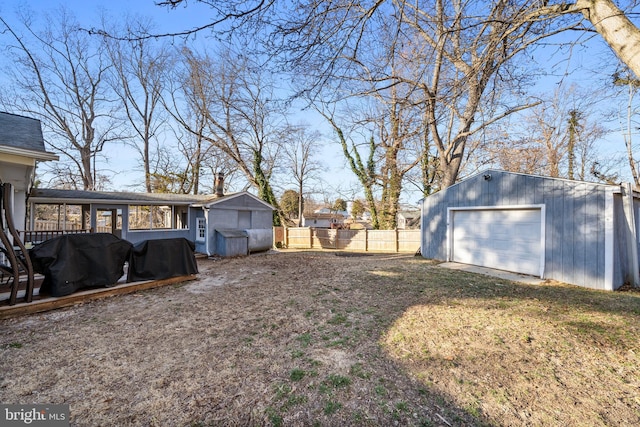 view of yard with a garage, an outdoor structure, and fence