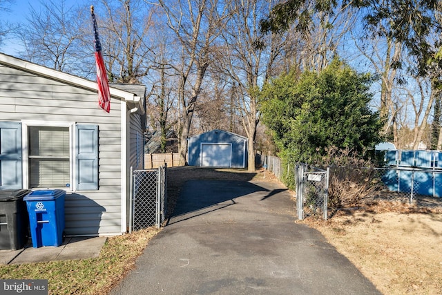 exterior space featuring aphalt driveway, a gate, and fence