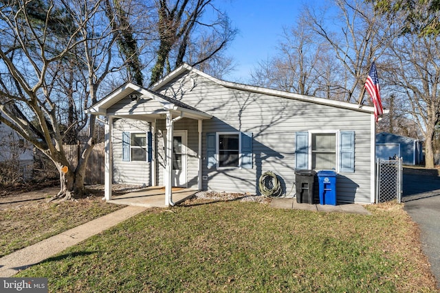 bungalow-style house with a front yard and covered porch