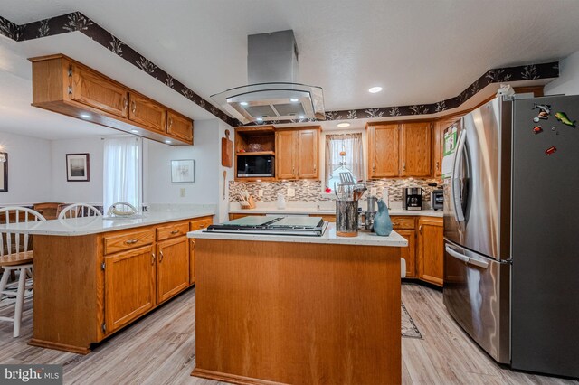 701 Paris Kirby Rd, Milford, DE 19963 - kitchen featuring stainless steel appliances, island range hood, light wood-style flooring, light countertops, and a peninsula