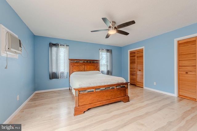 701 Paris Kirby Rd, Milford, DE 19963 - bedroom featuring light wood-style flooring, multiple closets, baseboards, an AC wall unit, and a ceiling fan