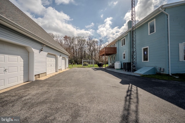 701 Paris Kirby Rd, Milford, DE 19963 - view of side of property featuring asphalt driveway, central air condition unit, a garage, and a deck
