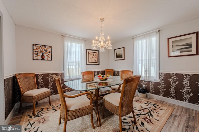 701 Paris Kirby Rd, Milford, DE 19963 - dining room with light wood-type flooring, a chandelier, baseboards, wainscoting, and wallpapered walls