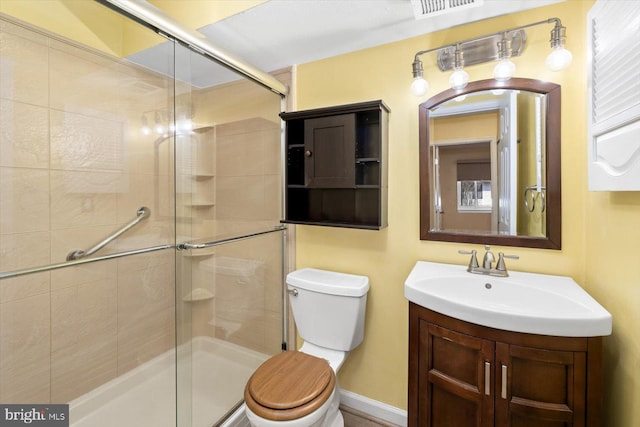 bathroom featuring toilet, a stall shower, visible vents, and vanity