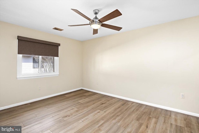 unfurnished room with a ceiling fan, baseboards, visible vents, and wood finished floors