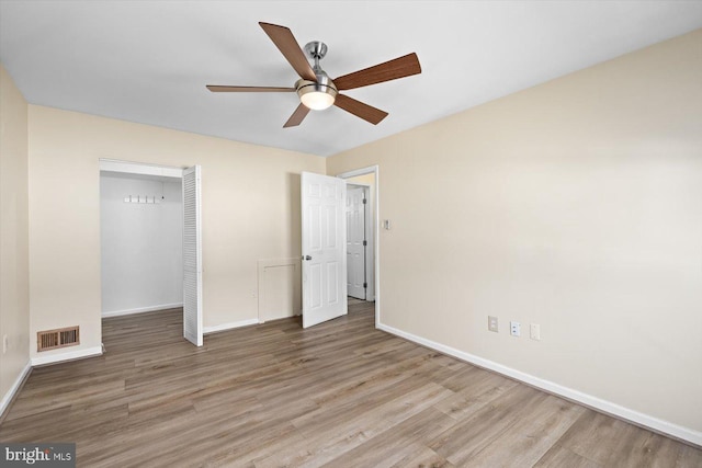 unfurnished bedroom featuring a closet, visible vents, baseboards, and wood finished floors