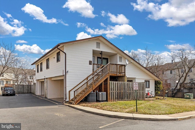 view of front facade featuring cooling unit, fence, stairway, and a front yard