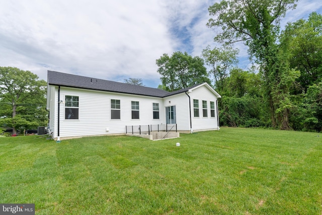 back of property featuring a yard and central AC