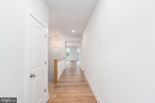 hallway with light wood-type flooring and baseboards