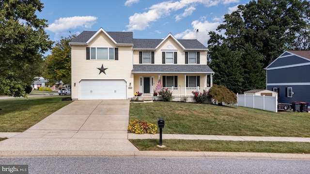 traditional-style house featuring a porch, a front yard, driveway, and an attached garage