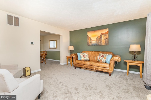 living area with carpet, visible vents, and baseboards