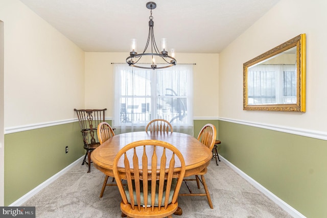 dining room featuring carpet floors, baseboards, and a notable chandelier