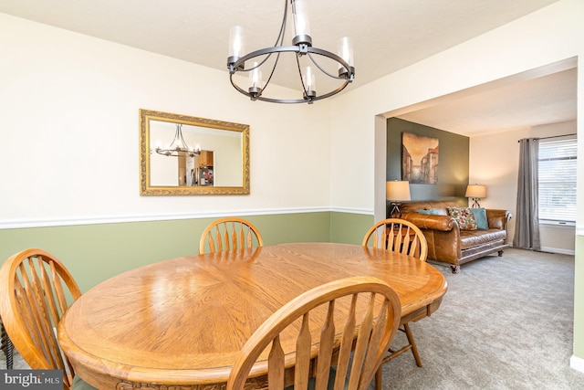 dining area with carpet and a chandelier