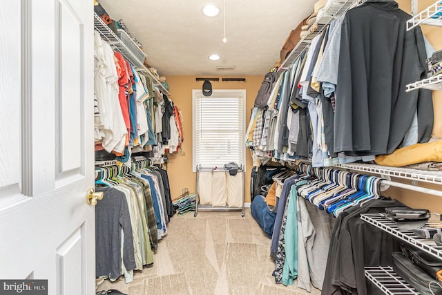 spacious closet featuring visible vents and light colored carpet