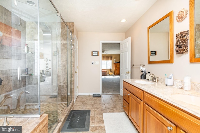 bathroom featuring double vanity, a stall shower, a sink, and connected bathroom