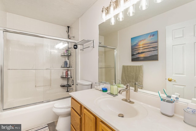 bathroom with shower / bath combination with glass door, vanity, toilet, and a textured ceiling