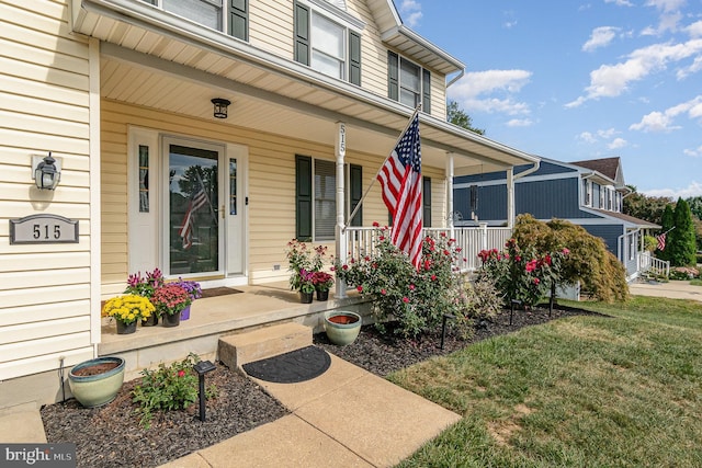 property entrance with covered porch and a yard