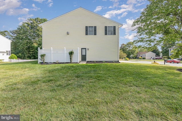 view of side of home with a yard and fence