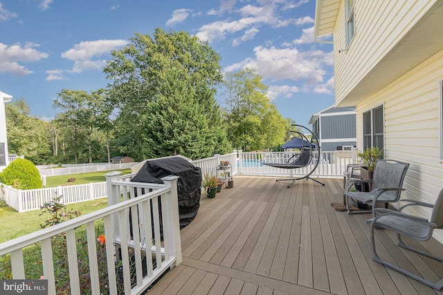 wooden terrace with a fenced backyard, a fenced in pool, and a lawn