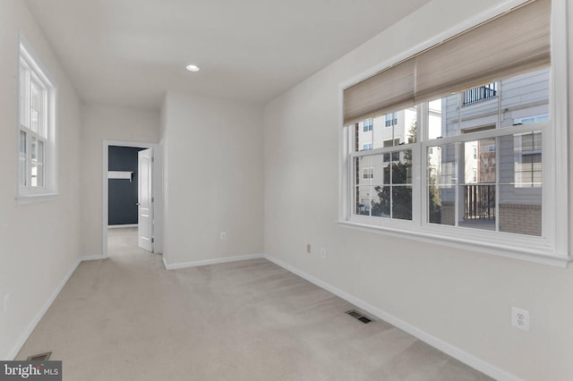 carpeted spare room with recessed lighting, visible vents, and baseboards