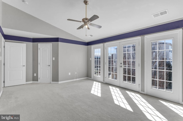 carpeted spare room featuring french doors, visible vents, vaulted ceiling, ceiling fan, and baseboards