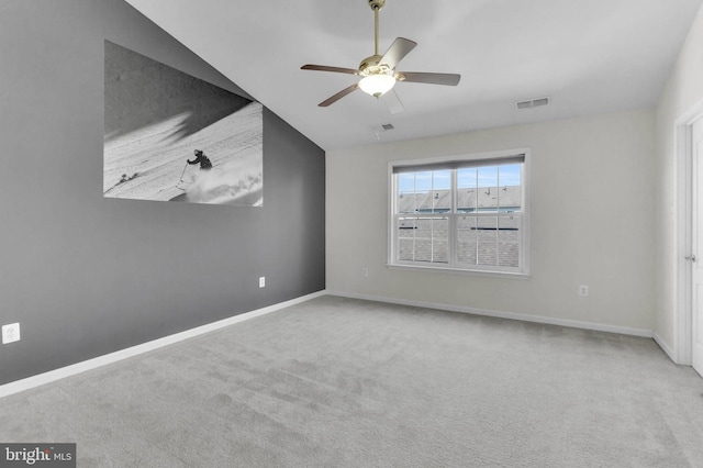 carpeted spare room with visible vents, ceiling fan, and baseboards