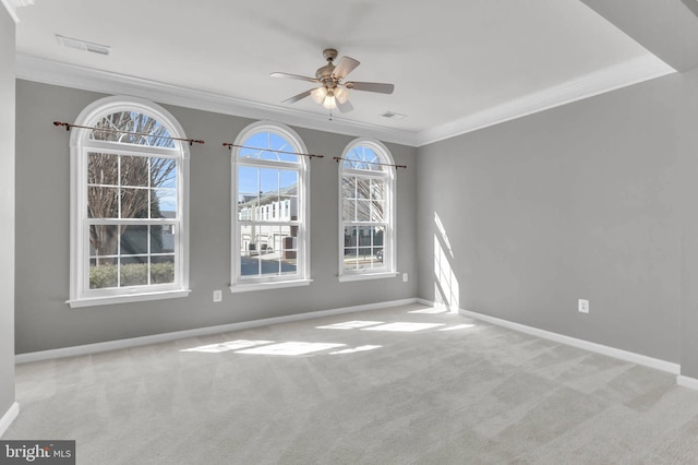 empty room featuring baseboards, carpet floors, visible vents, and crown molding