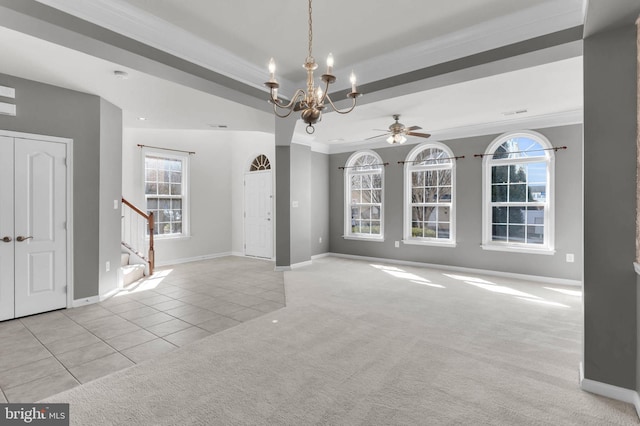 interior space with stairs, a tray ceiling, ornamental molding, and tile patterned floors