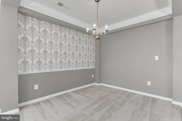 spare room featuring a notable chandelier, visible vents, ornamental molding, carpet flooring, and baseboards