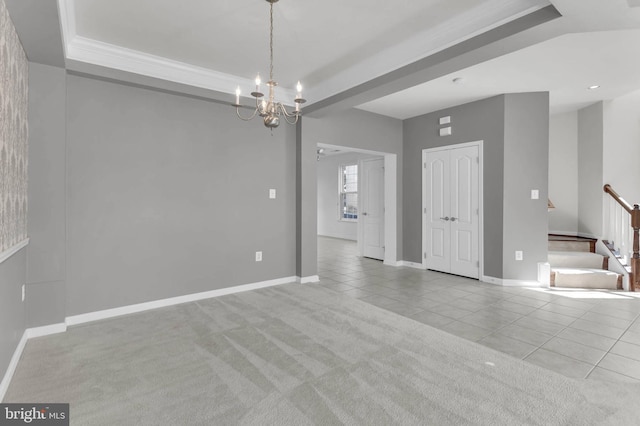 carpeted empty room with stairs, baseboards, a raised ceiling, and tile patterned floors