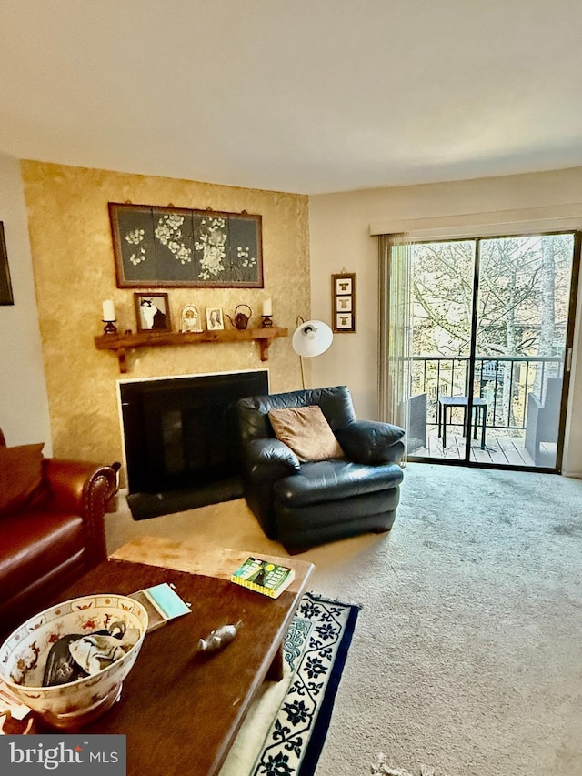 living area featuring carpet and a glass covered fireplace