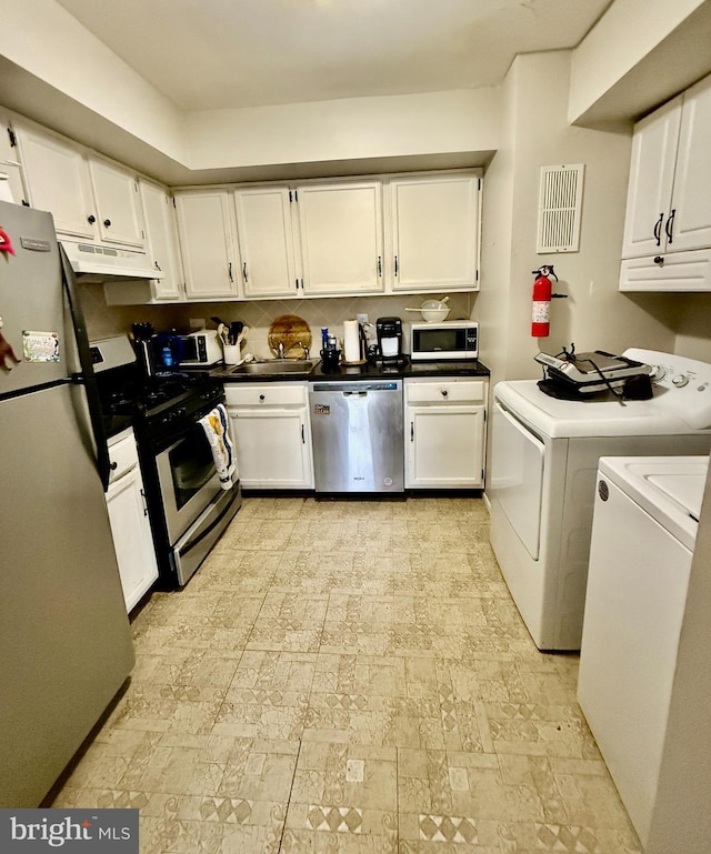 kitchen with visible vents, appliances with stainless steel finishes, white cabinetry, washer and dryer, and under cabinet range hood