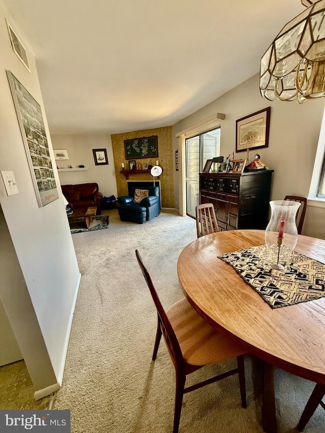 dining space featuring carpet floors and a large fireplace