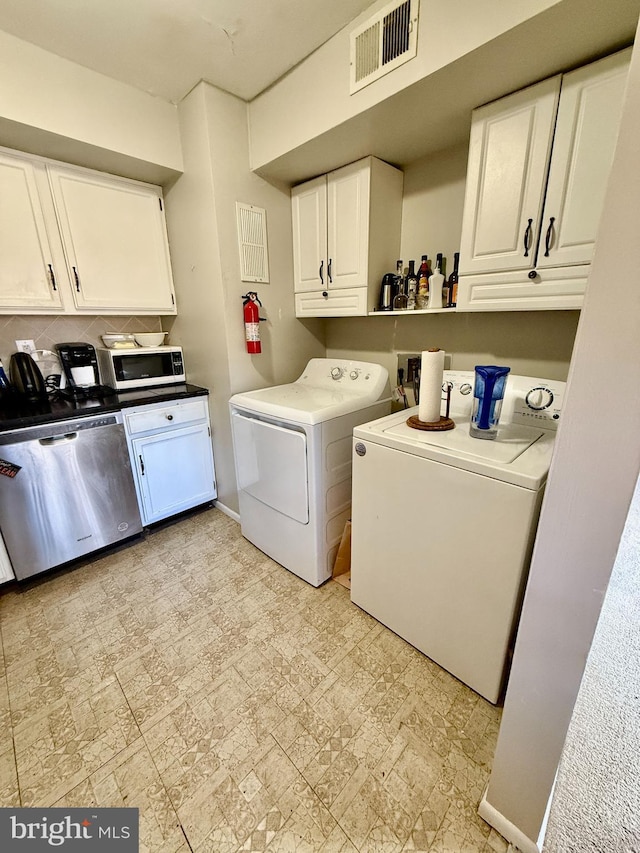 laundry area featuring laundry area, visible vents, baseboards, and washing machine and clothes dryer