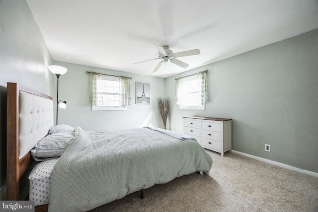 bedroom with a ceiling fan, light colored carpet, and baseboards