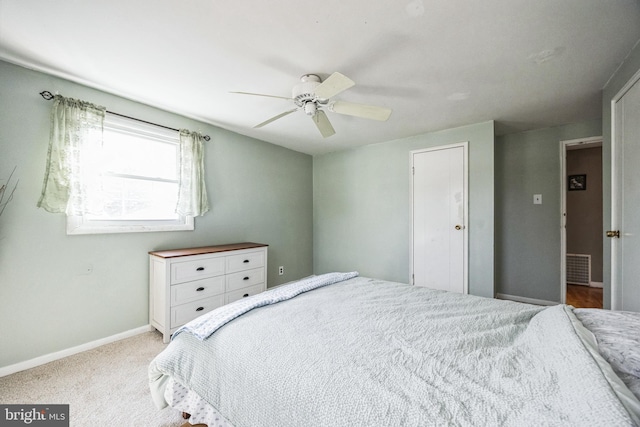 bedroom featuring a ceiling fan, light colored carpet, visible vents, and baseboards