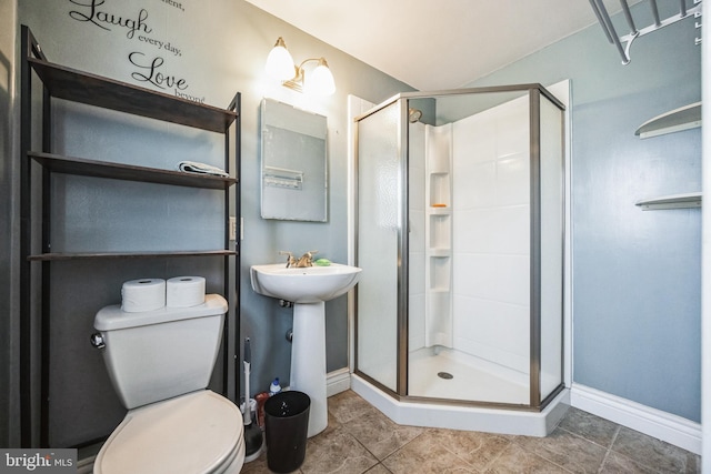 bathroom with toilet, a sink, a shower stall, tile patterned flooring, and baseboards