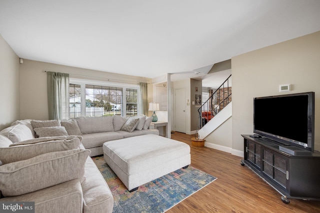 living area featuring stairway, wood finished floors, and baseboards