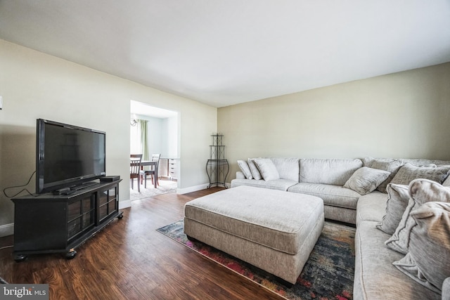 living area with baseboards and wood finished floors