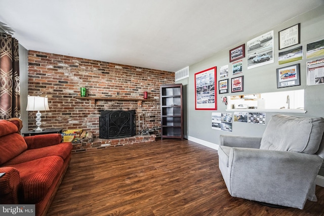 living room with visible vents, a fireplace, baseboards, and wood finished floors