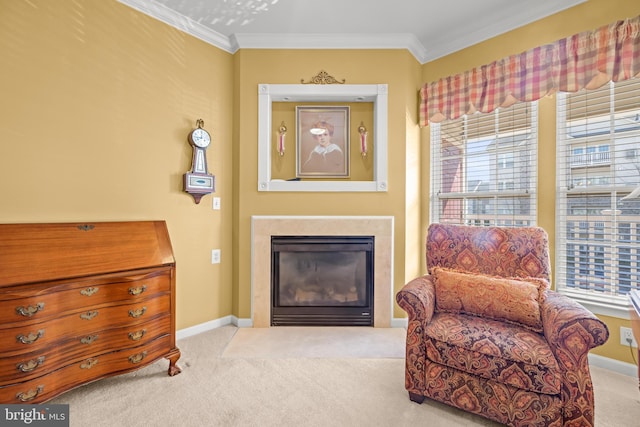 sitting room with a glass covered fireplace, carpet flooring, a healthy amount of sunlight, and ornamental molding