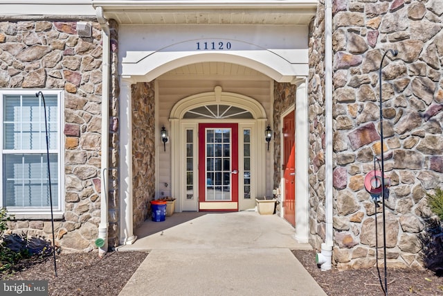 doorway to property featuring stone siding