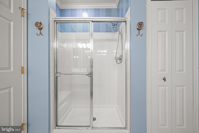 bathroom featuring a shower stall, crown molding, and a closet