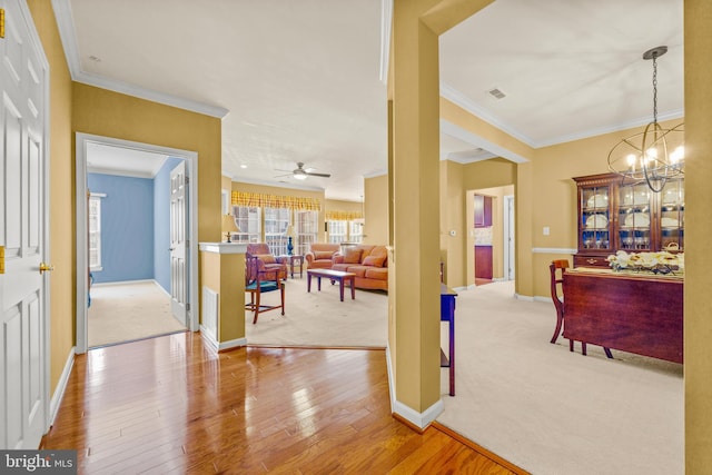 interior space with visible vents, hardwood / wood-style flooring, baseboards, and ornamental molding