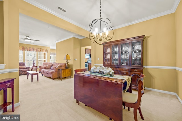 dining area with crown molding, light colored carpet, baseboards, and visible vents